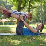 Foto von Beata und von Tochter, die Übungen in einem Park tun